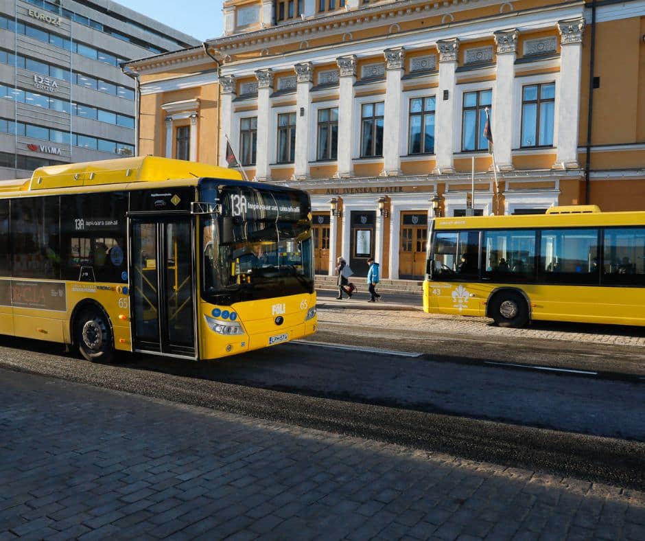 Kaksi Fölin keltaista bussia Turun Kauppatorin laidalla. Takana on Kop-kolmio ja ruotsalainen teatteri.